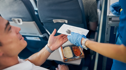Passenger eating a meal on board a plane