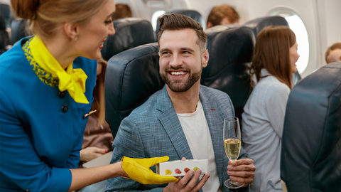Flight attendant offering cookies to a passenger