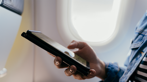 Passenger holding a smartphone inside an airplane