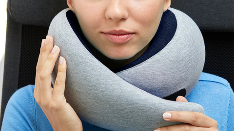 Woman resting with a travel pillow on a plane